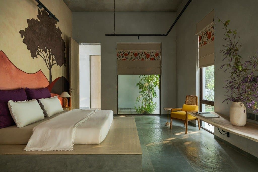 Guest bedroom with green hand-polished flooring and custom tree mural