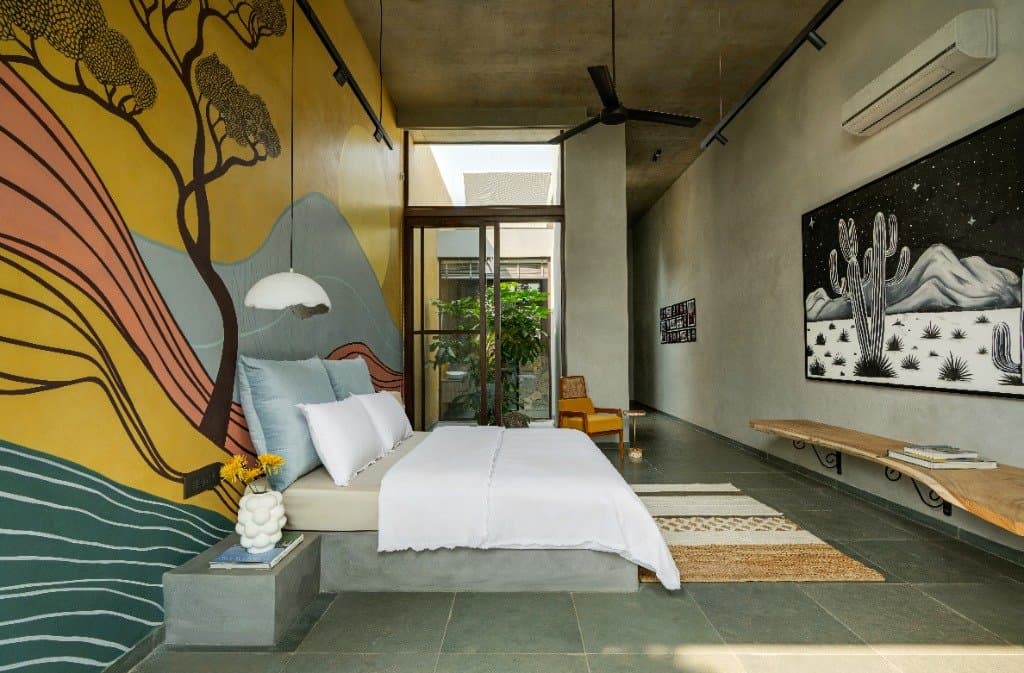 Guest bedroom featuring yellow mountain mural and desert cactus painting