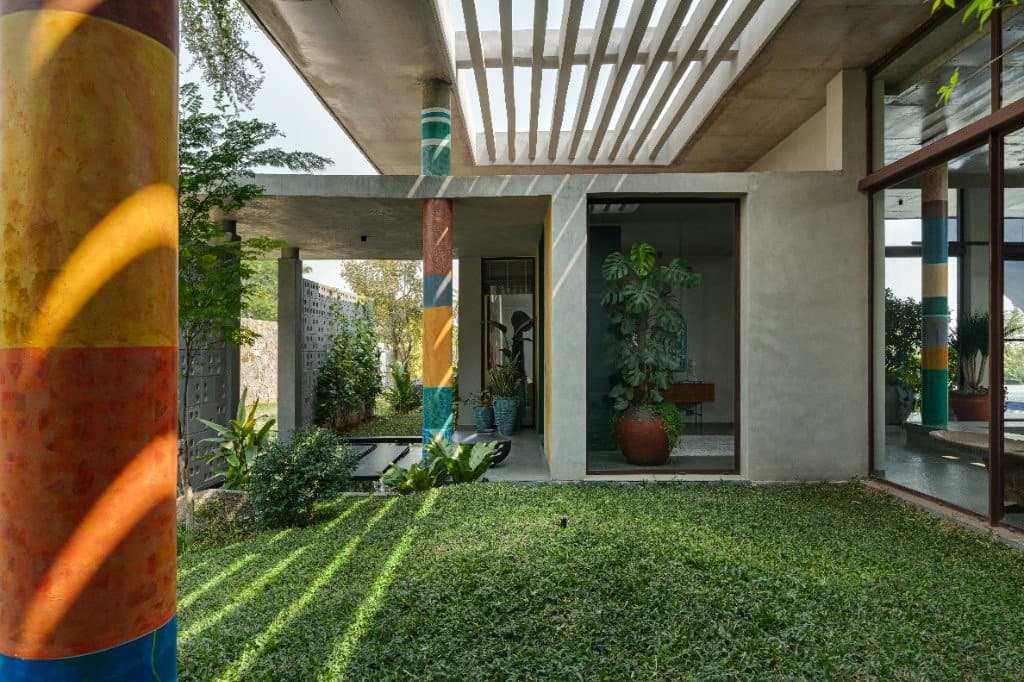 Courtyard pillars with hand-painted colorful bands looking onto the lawn