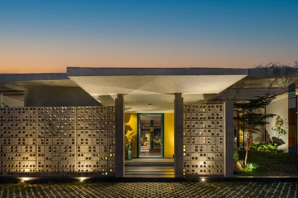 SAHN dusk entrance with concrete canopy and architectural screen